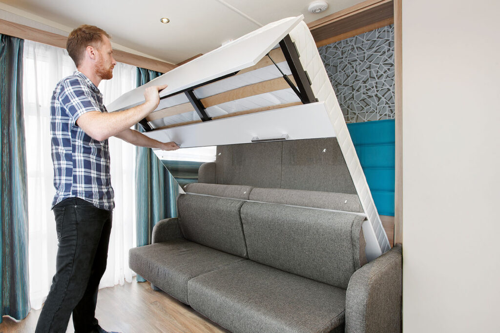 man taking out sofa bed in 2 berth glamping pod