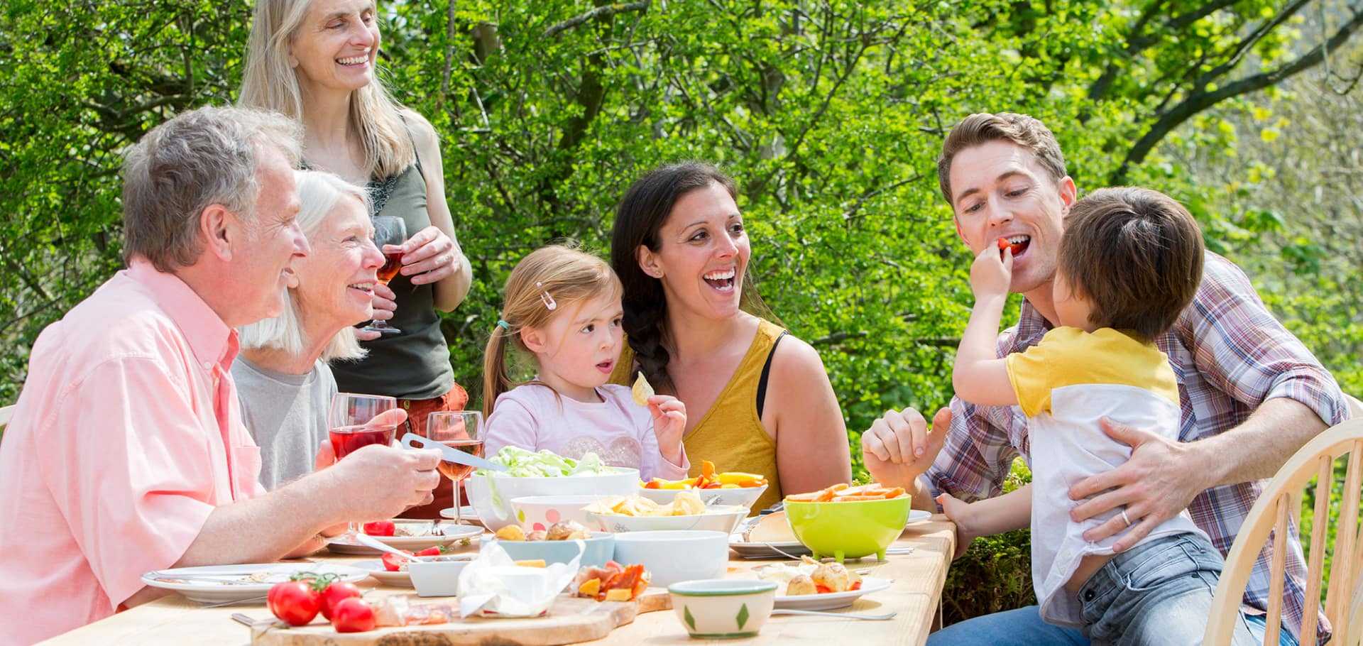 Family enjoying a garden picnic at a table