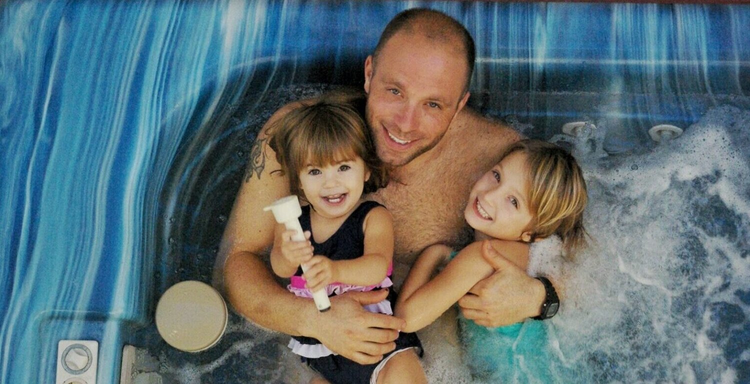 Man and daughters relaxing in hottub